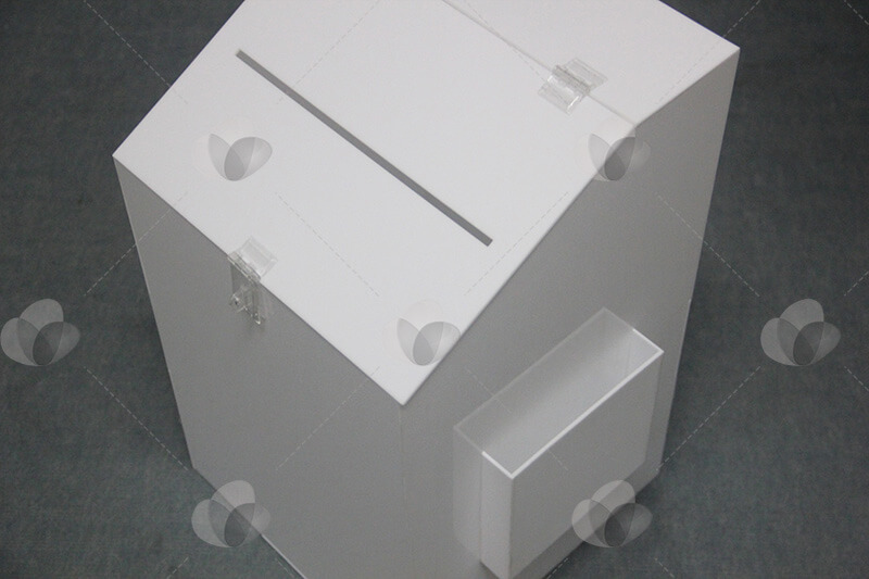 Urna em acrílico branco com bolso lateral para exibição de folders ou formulários a serem preenchidos